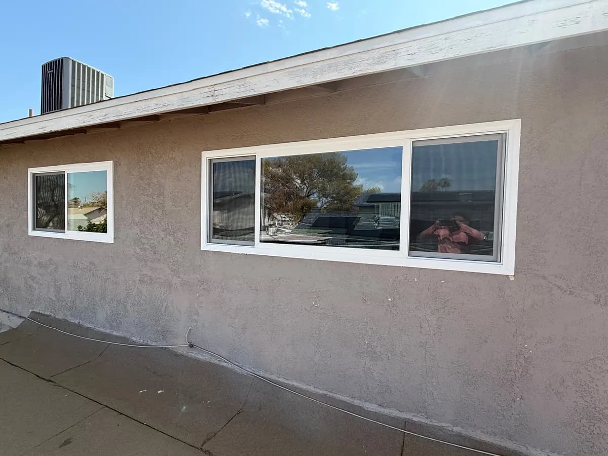 Row of horizontal windows along a stucco wall.