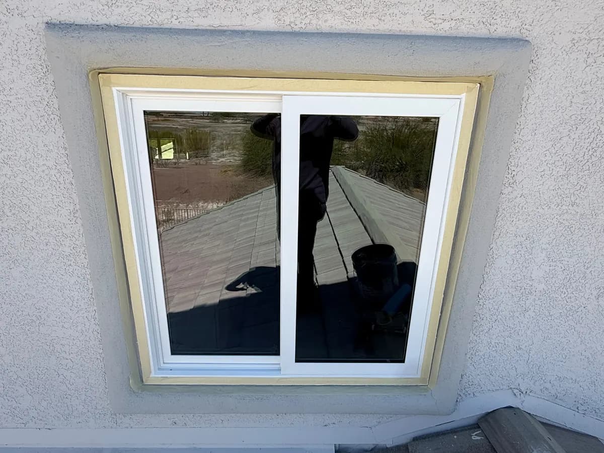 Window opening during installation, with flashing tape applied around the frame.